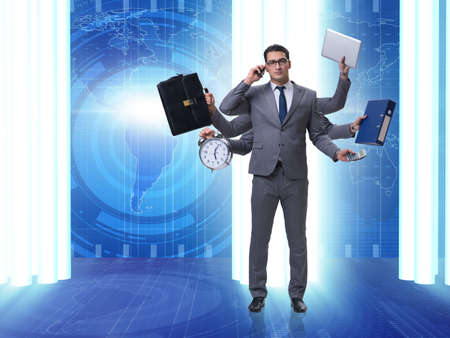 Young businessman in multitasking conceptの写真素材
