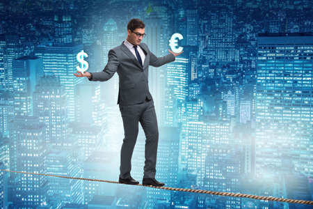 Businessman balancing between choosing dollar and euroの写真素材