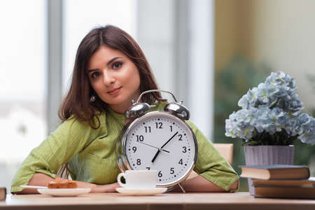 Student with gian alarm clock preparing for exams