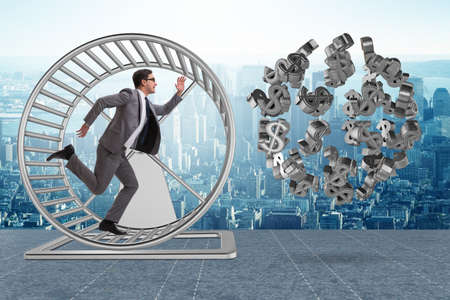 Business concept with businessman running on hamster wheelの写真素材