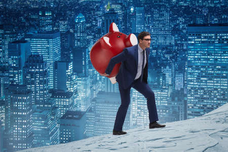 Businessman carrying the piggybank with savingsの写真素材