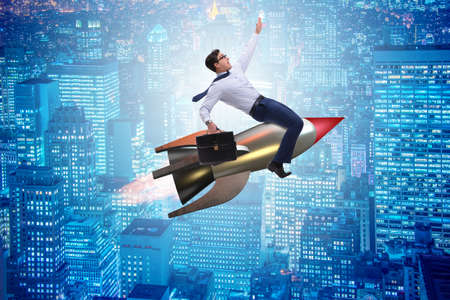 Businessman flying on rocket in business conceptの写真素材