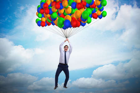 Businessman flying on balloons in challenge conceptの写真素材