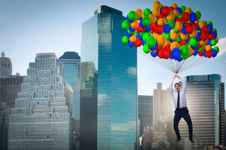 Businessman flying on balloons in challenge conceptの写真素材