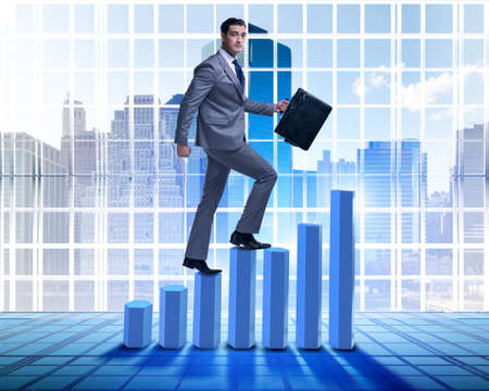 Businessman climbing bar charts in business conceptの写真素材