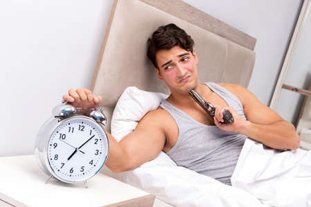 Young man having trouble waking up in the morningの写真素材