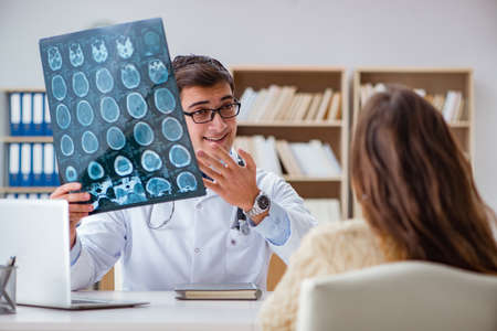 Young doctor looking at computer tomography x-ray imageの写真素材