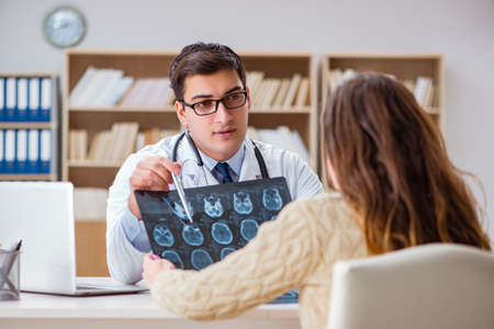 Young doctor looking at computer tomography x-ray imageの写真素材