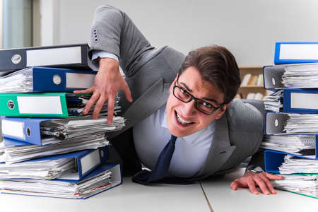 Businessman under stress due to excessive workの写真素材