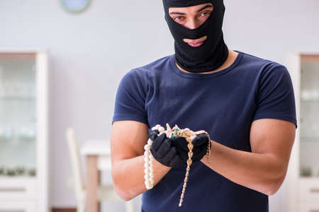 Robber wearing balaclava stealing valuable thingsの写真素材