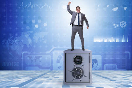 Excited businessman standing on top of safeの写真素材
