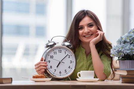 Student with gian alarm clock preparing for exams