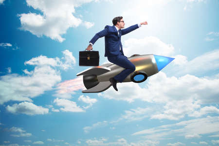 Businessman flying on rocket in business conceptの写真素材