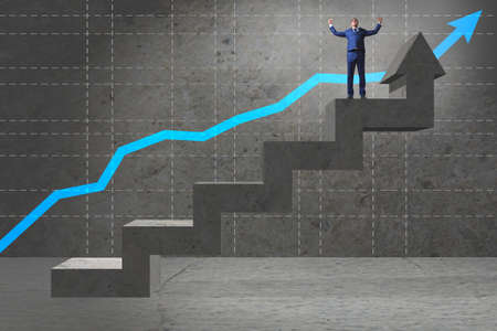 Young businessman climbing career ladderの写真素材