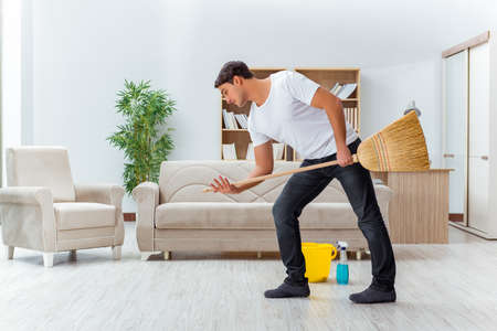 Man husband cleaning the house helping wifeの写真素材