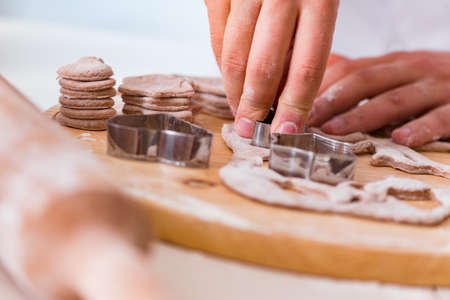 Young man cooking cookies in kitchenの写真素材