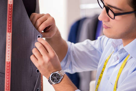 Young man tailor working on new clothing