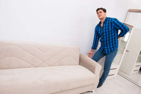 Young man moving sofa couchの写真素材