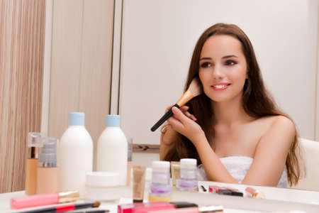Woman doing make-up at home preparing for partyの写真素材