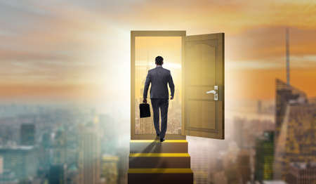 Businessman walking towards open doorの写真素材