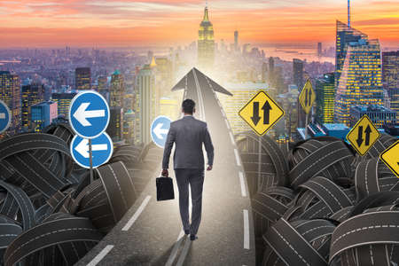 Businessman in uncertainty concept on road intersection crossroaの写真素材