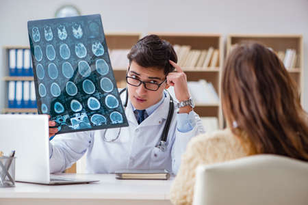 Young doctor looking at computer tomography x-ray imageの写真素材