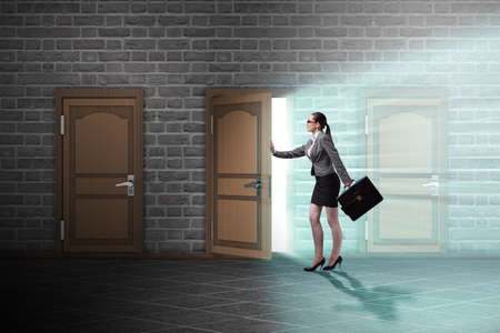 Businesswoman walking towards open doorの写真素材