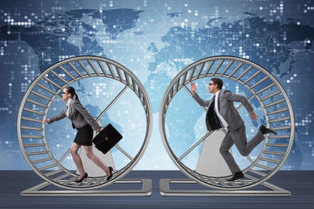 Business concept with pair running on hamster wheelの写真素材