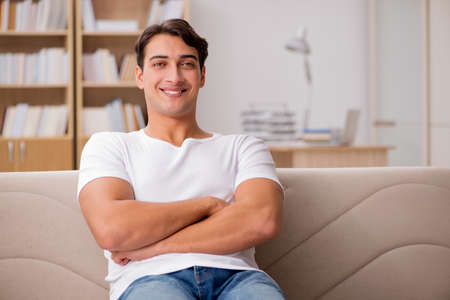 Young man relaxing sitting in couch sofaの写真素材