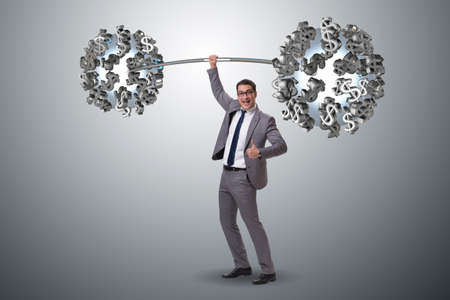 Businessman lifting barbell with dollarsの写真素材
