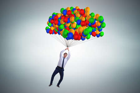 Businessman flying on balloons in challenge conceptの写真素材