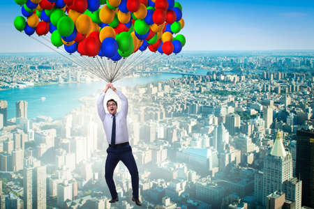 Businessman flying on balloons in challenge conceptの写真素材