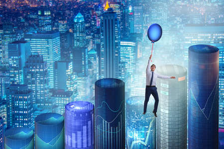 Businessman flying on hot balloon over graphの写真素材