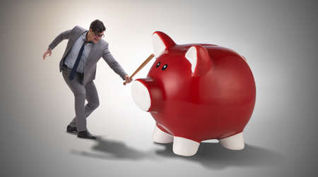 Angry man with baseball bat hitting piggybankの写真素材