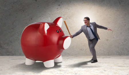 Angry man with baseball bat hitting piggybankの写真素材