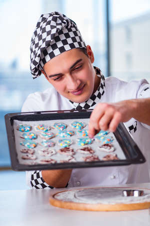 Young man cooking cookies in kitchenの写真素材