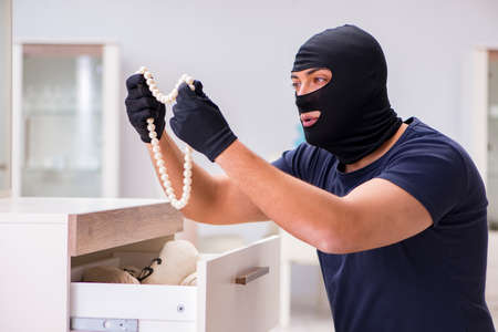 Robber wearing balaclava stealing valuable thingsの写真素材
