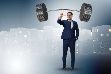 Businessman under  heavy burden of taxesの写真素材