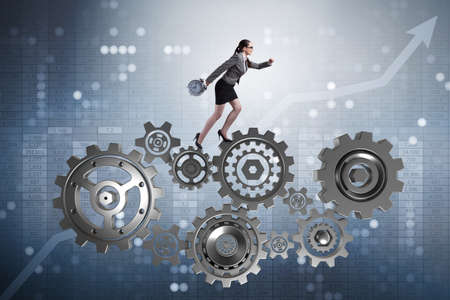 Woman businesswoman walking in cogwheelsの写真素材