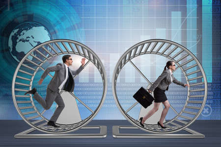 Business concept with pair running on hamster wheelの写真素材