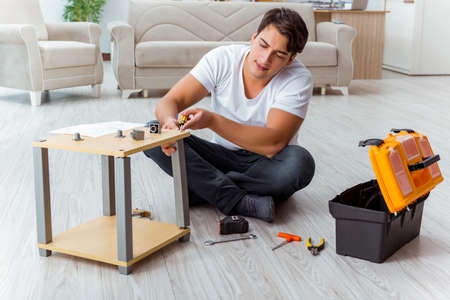 Man assembling furniture at homeの写真素材