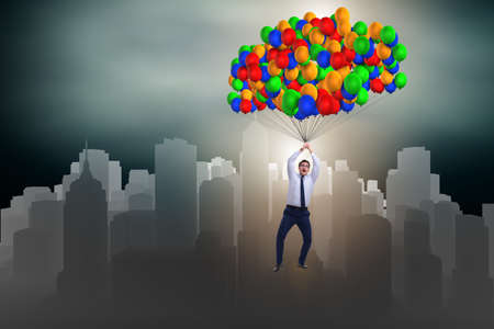 Businessman flying on balloons in challenge conceptの写真素材