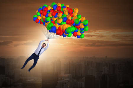 Businessman flying on balloons in challenge conceptの写真素材