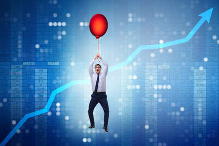Businessman flying on hot balloon over graph