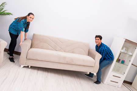 Wife and husband moving sofa couchの写真素材