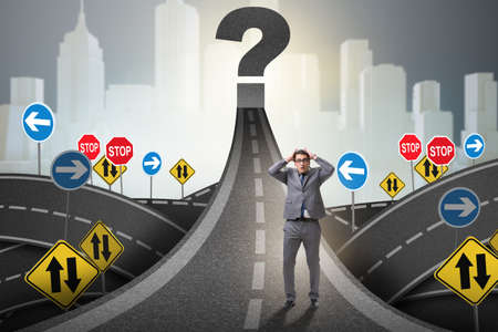 Businessman in uncertainty concept on road intersection crossroaの写真素材