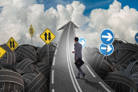 Businessman in uncertainty concept on road intersection crossroaの写真素材