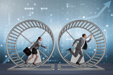 Business concept with pair running on hamster wheelの写真素材