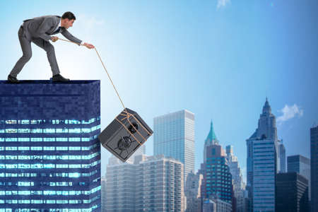 Businessman stealing safe from buildingの写真素材