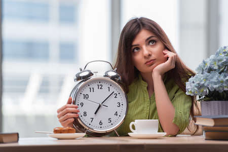 Student with gian alarm clock preparing for exams